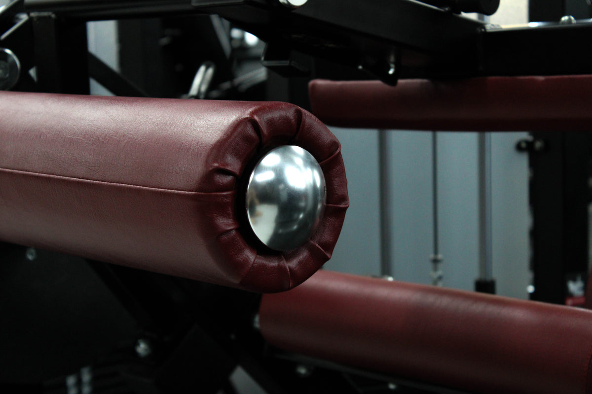 Reload Leg Curl machine - matte black frame red seat in commercial gym