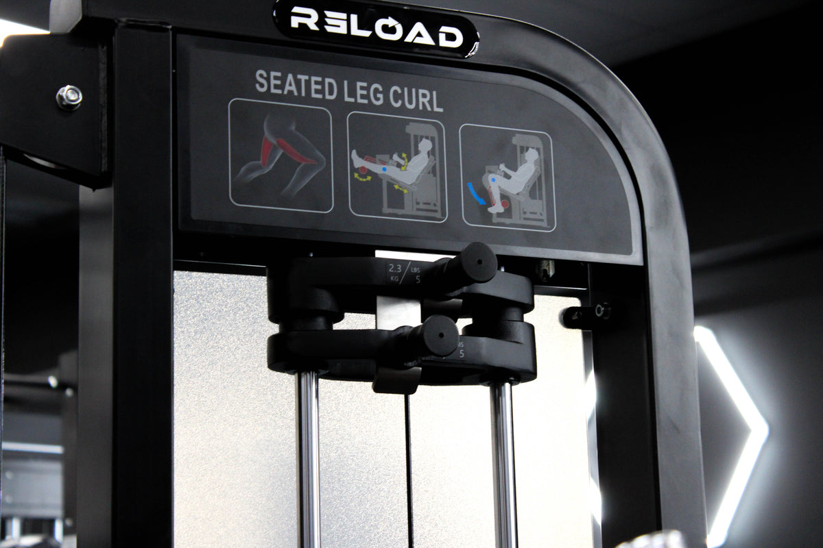 Reload Leg Curl machine - matte black frame red seat in commercial gym