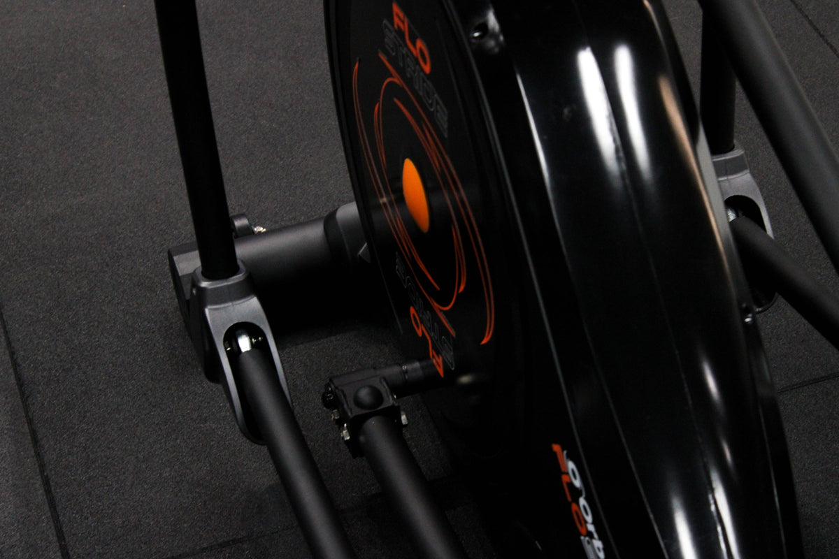 Close-up of a FLO STRIDE exercise bike with orange and black design.