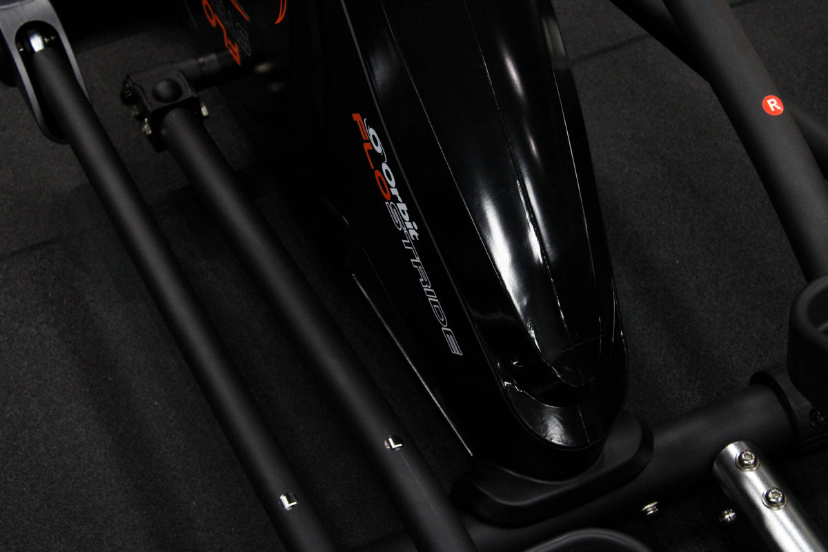 Close-up of a FLO STRIDE exercise bike with orange and black design.