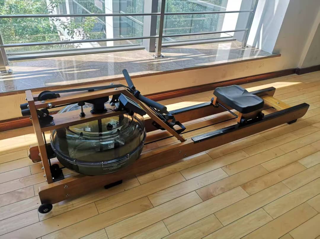 Reload Water Rower showing ergonomic seat, dual rails, and LCD console Setup in a gym