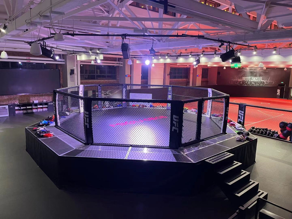MMA octagon ring in an indoor sports facility with visible branding.
