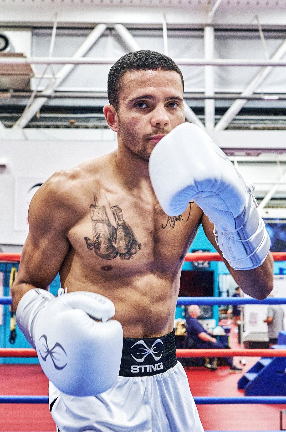 Boxer in a boxing ring wearing white sting gloves and shorts