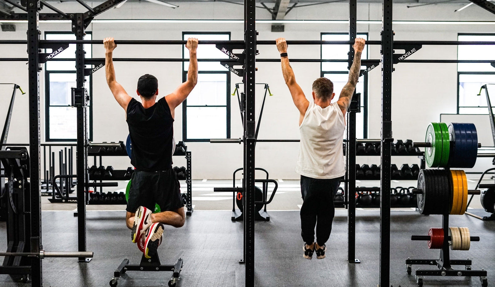 Guys training in the gym doing pull ups