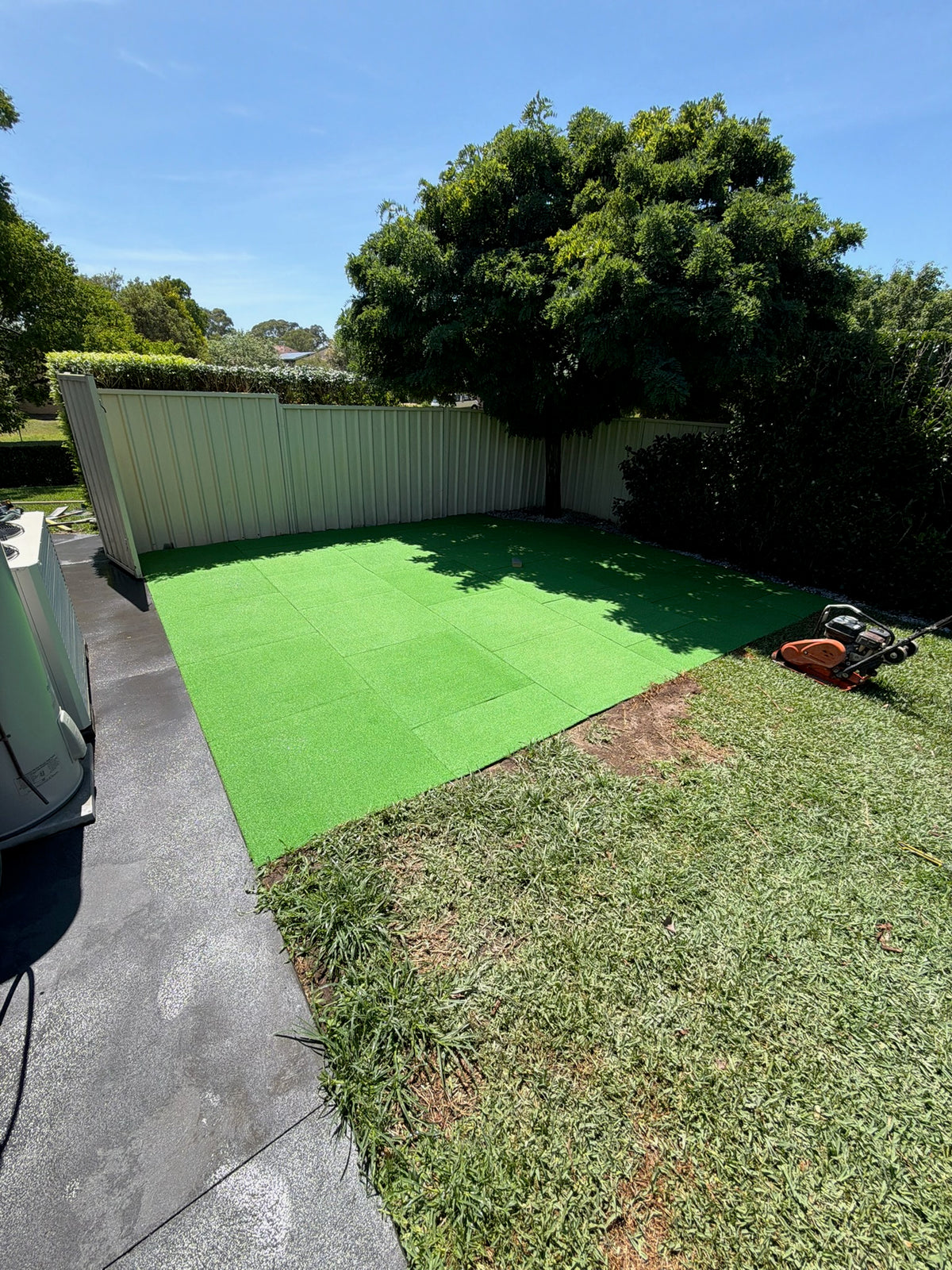 Green artificial grass installed on in garden area