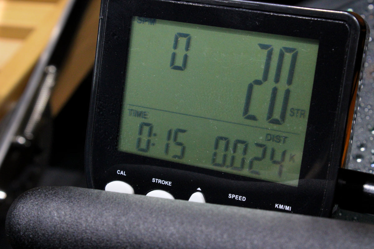 Reload Water Rower on gym floor showing ergonomic seat, dual rails, and LCD console