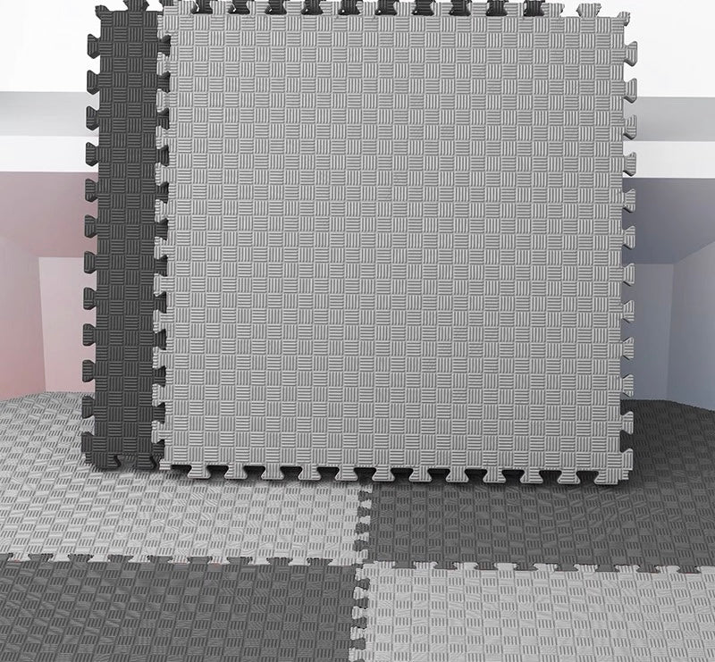 Grey interlocking foam mat with black border on a plain background