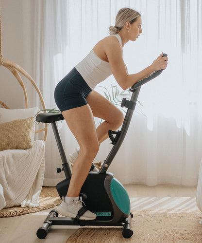 Side view of the compact FitClub Exercise Bike in a home setting