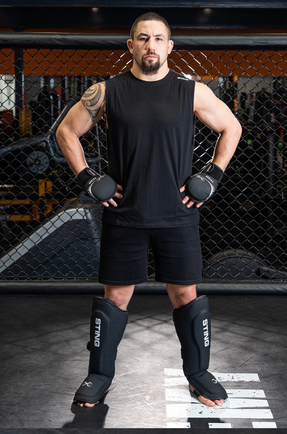 Robert Whittaker UFC fighter in black Sting wear with gloves and shin guards standing in a fighting stance.