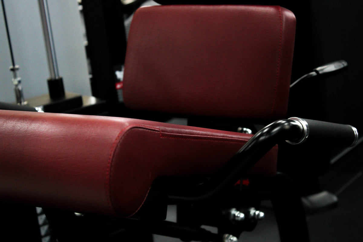 Reload Leg Curl machine - matte black frame red seat in commercial gym