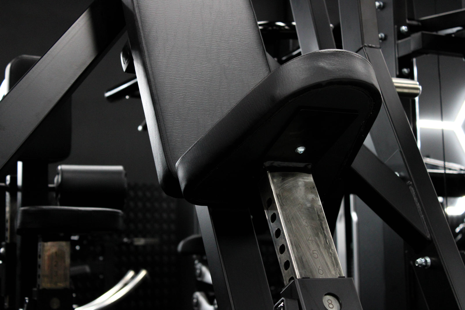 A red and black dual-station leg extension gym machine shown from a three-quarter angle on a solid white background.