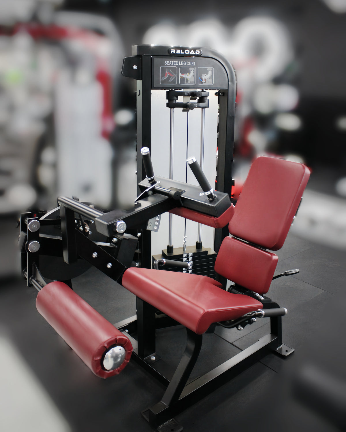 Reload Leg Curl machine - matte black frame red seat in commercial gym