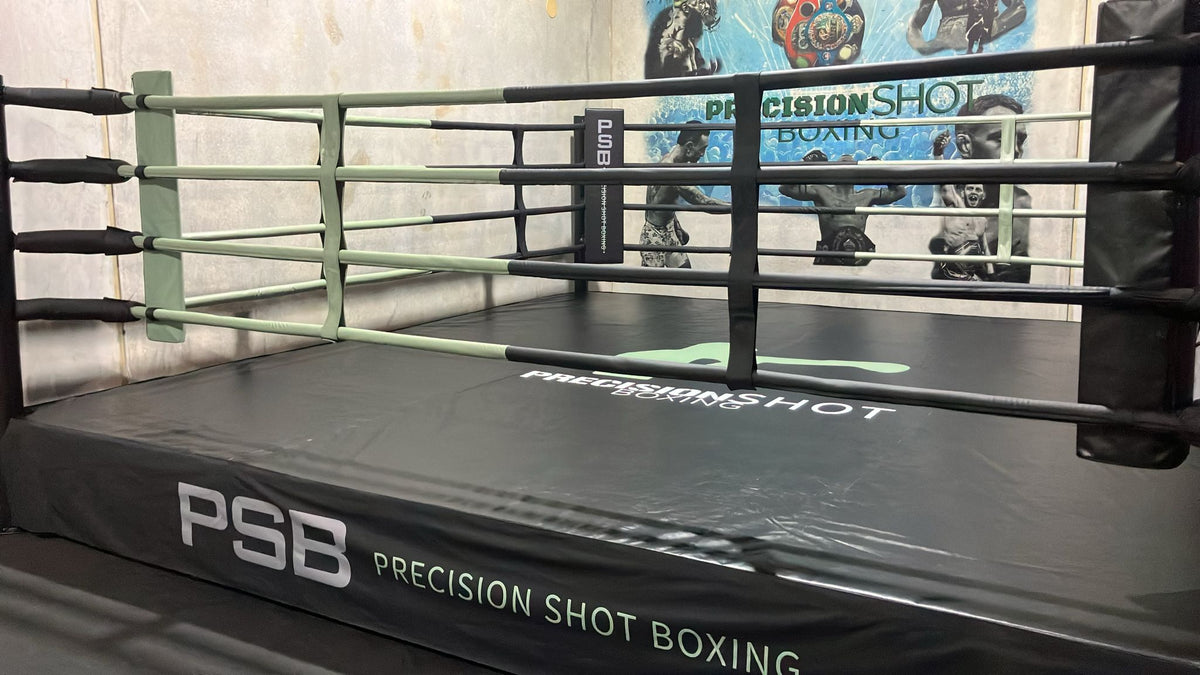 Boxing ring with 'PSB Precision Shot Boxing' branding on a concrete wall background
