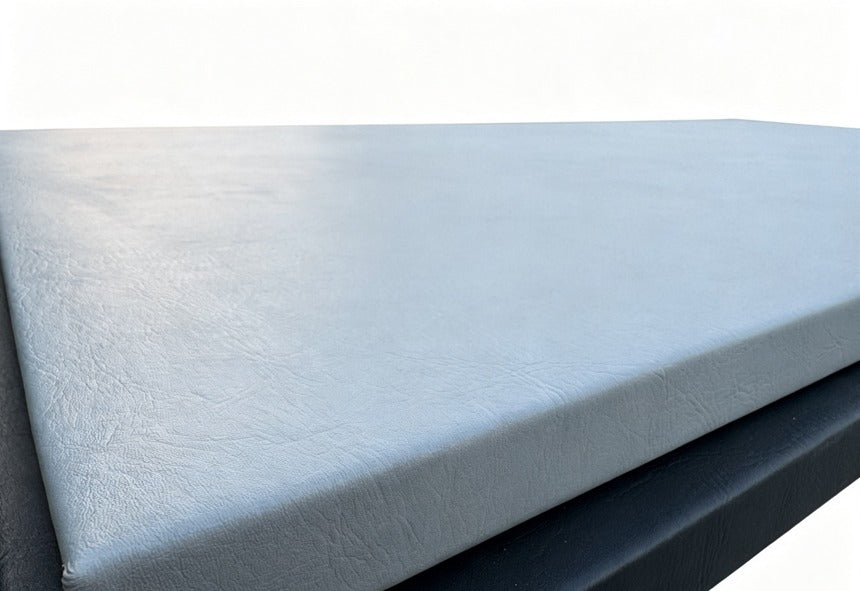 A rectangular gray foam mattress topper or cushion with a textured surface, shown at an angle on a plain white background.