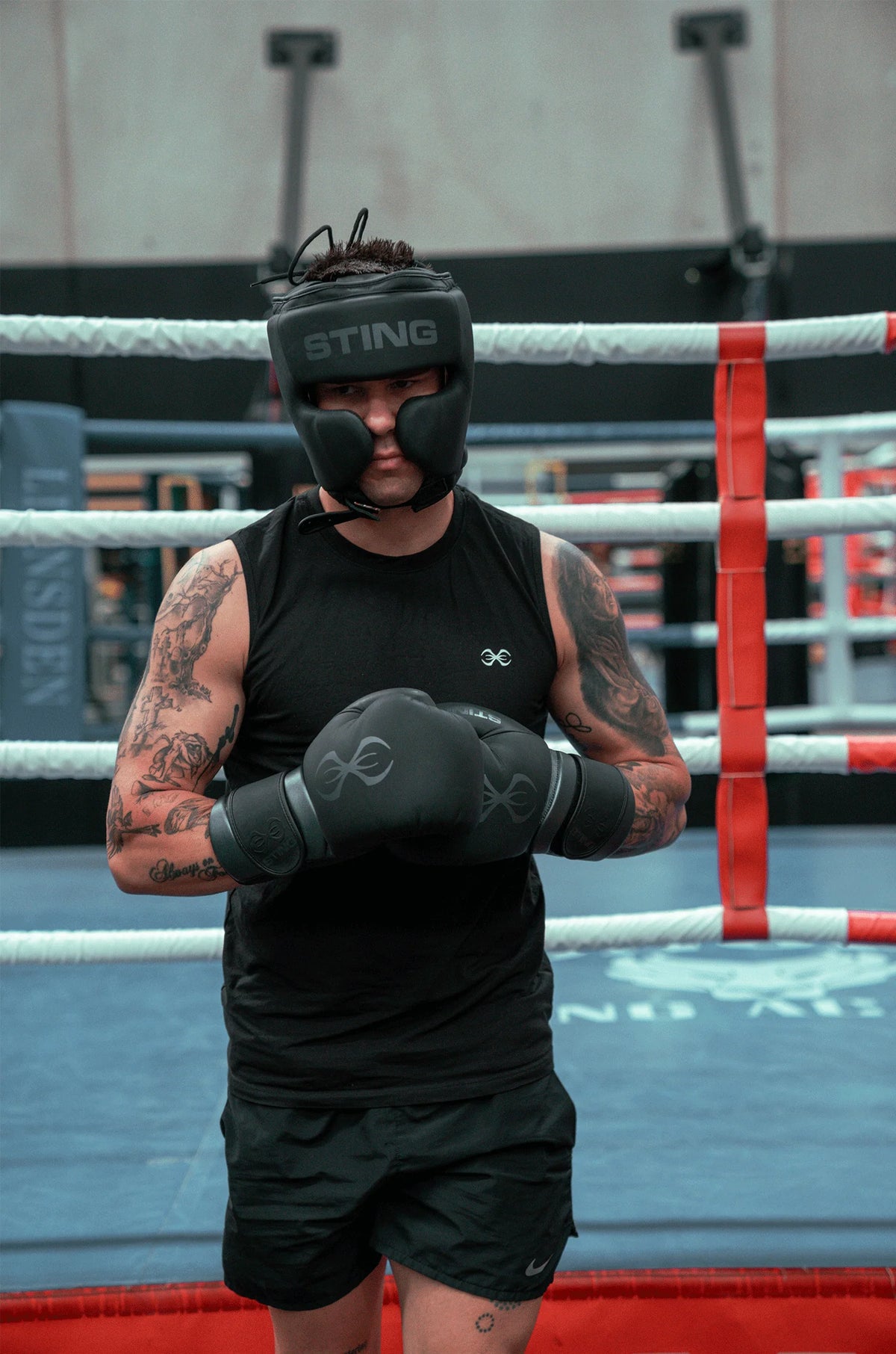 premium boxing gloves black grey sting training gear Man in boxing ring training