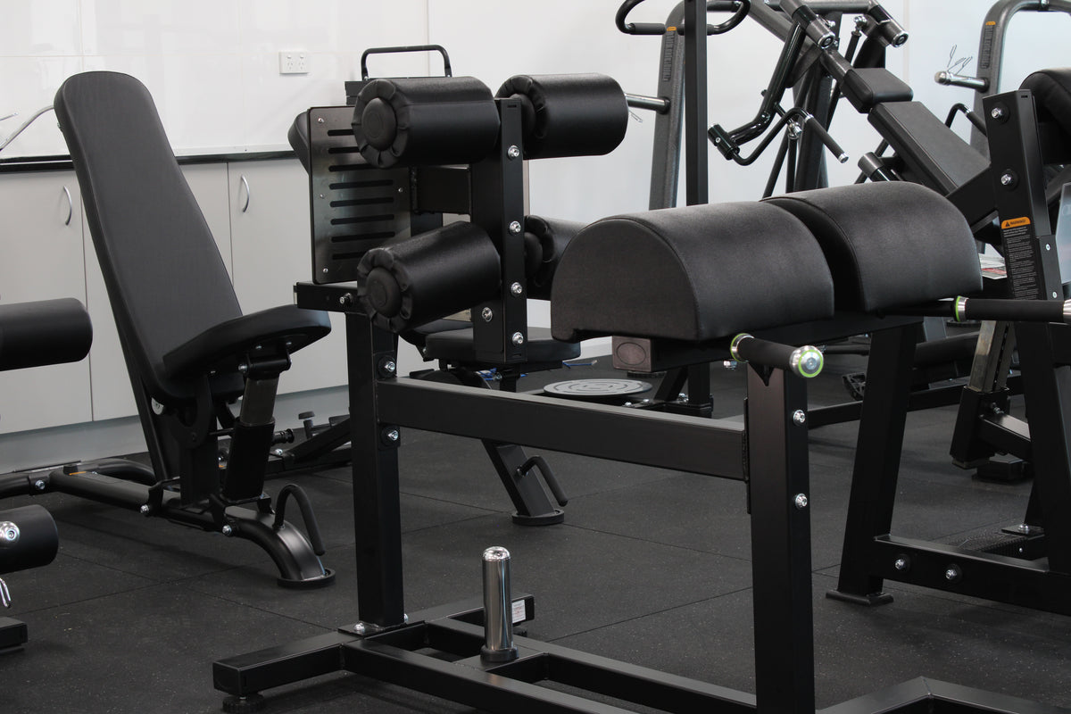 Dominator Glute Ham Developer GHD Machine - commercial grade black steel frame with adjustable ankle rollers and dual hip pads