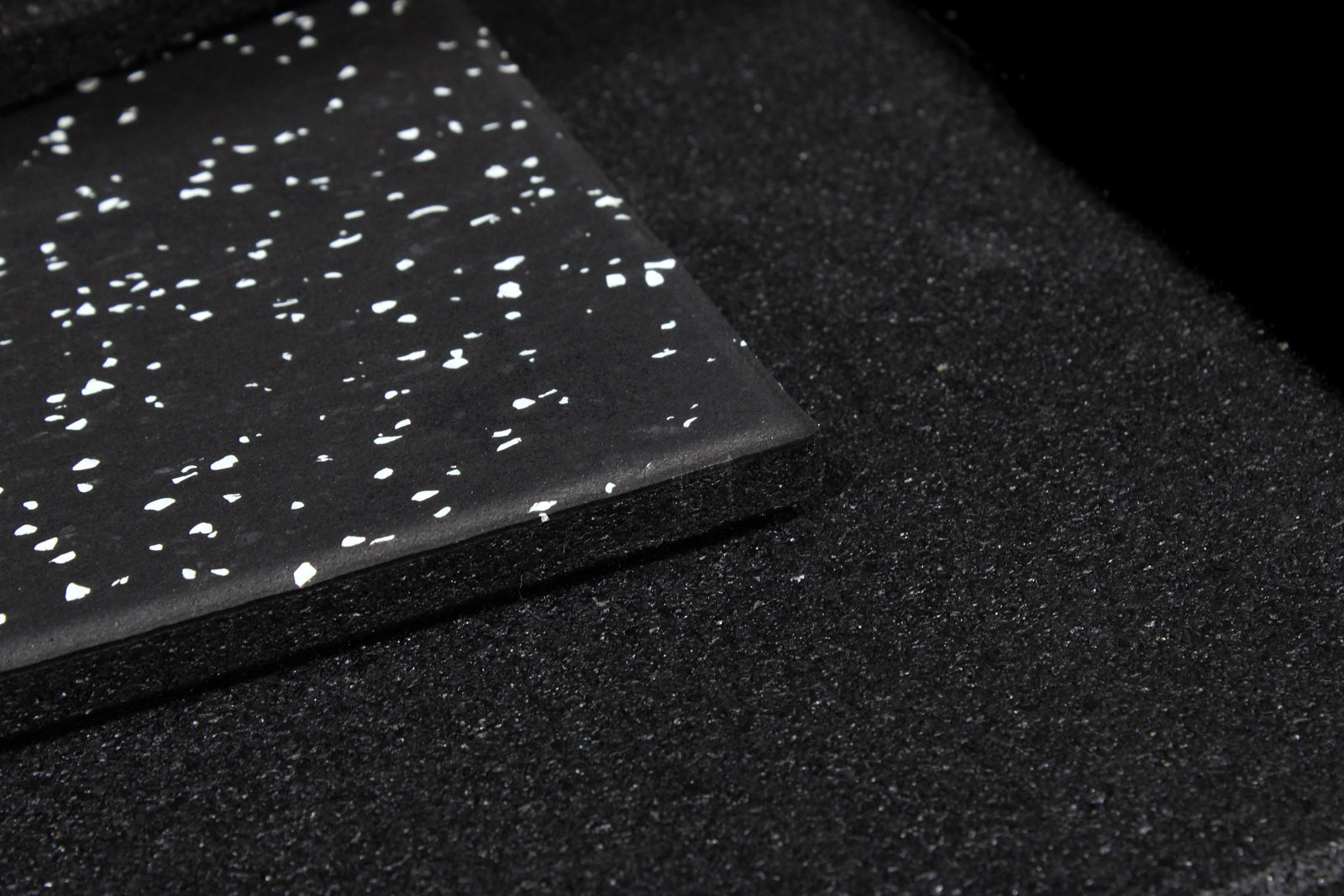 Black tile with grey speckles on a white background