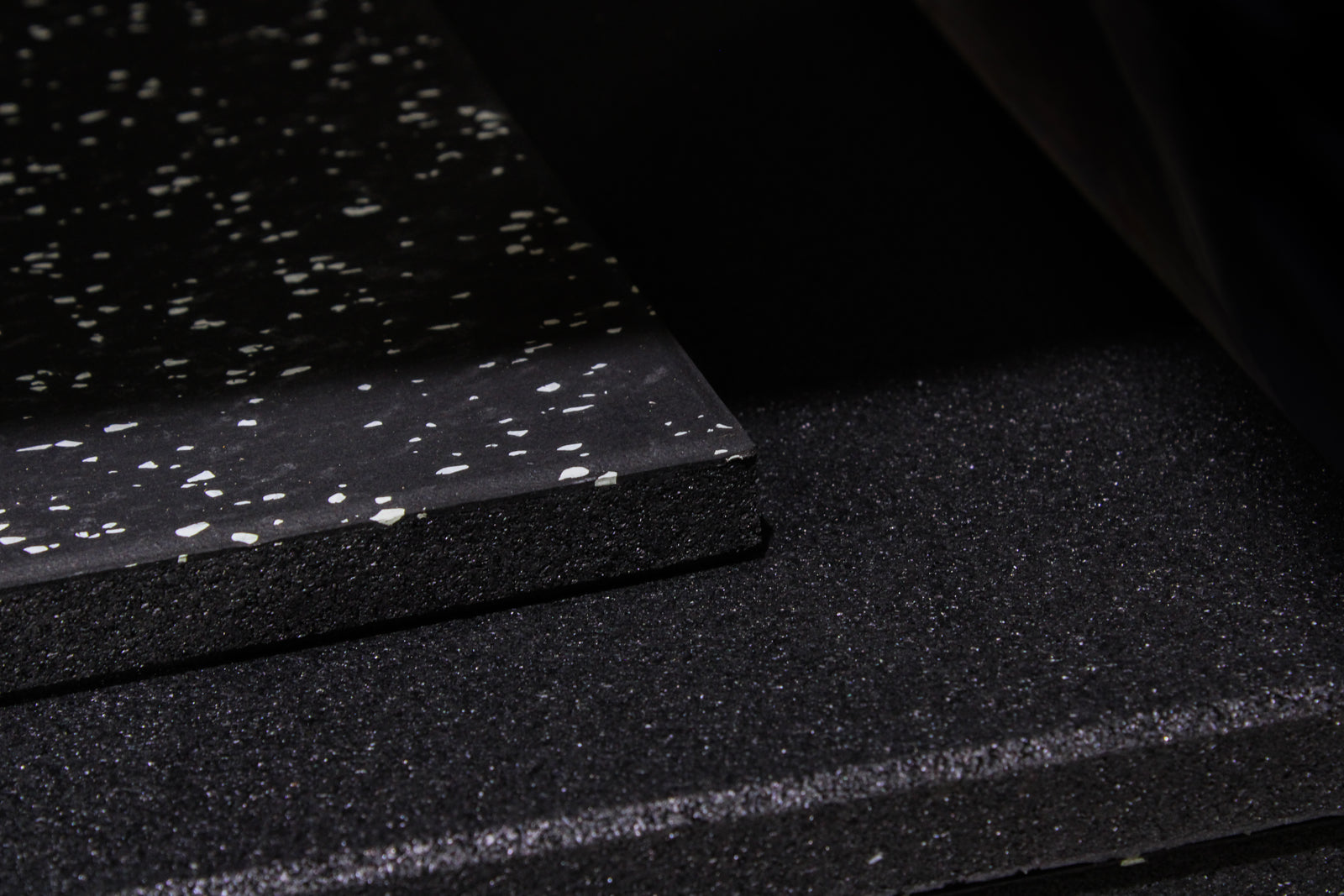 Black tile with grey speckles on a white background
