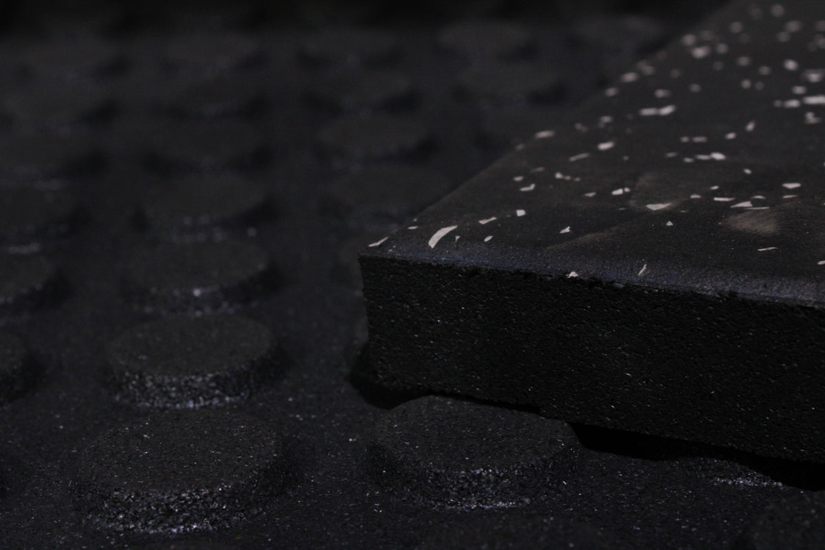 EPDM grey fleck rubber surface detail matching the 30mm gym flooring tiles the transition ramp is designed for.