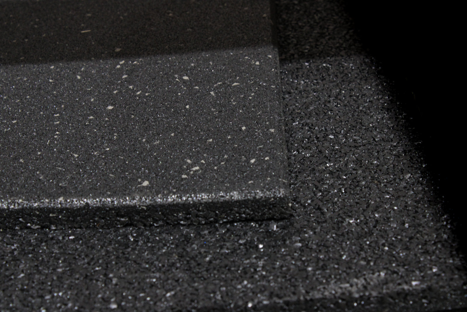 Black rubber mat with a speckled pattern on a white background